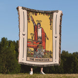 Blanket with 'The Magician' tarot card design held by a person outdoors.