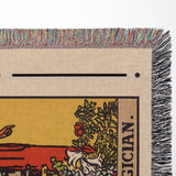 Close-up of a woven mat with colorful fringe, featuring a design of a hand pointing towards a tree and the word 'Magician'.
