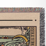 Close-up of a woven tapestry with intricate patterns and text, featuring a colorful fringe at the top.