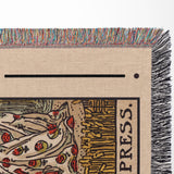 Textile with 'EMPRESS' print and colorful fringe on a beige background