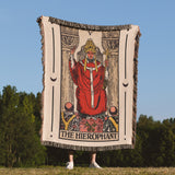 Person holding a Tarot card-themed blanket with 'The Hierophant' design outdoors.