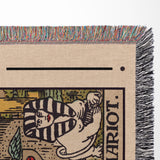 Close-up of a woven tarot blanket with a colorful fringe.