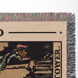 Close-up of tarot card design blanket featuring  text 'Tower' on a woven background.