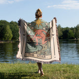Person holding a 'The Star' tarot card blanket by a lake