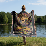 Person wearing a colorful 'Leo' themed blanket by a lake