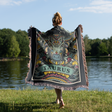 Person wearing a decorative Aries blanket by a lake