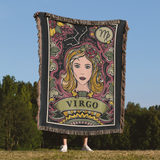 Person holding a decorative blanket with Virgo zodiac design against a natural background
