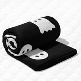 Black blanket with white ghost designs on a white background