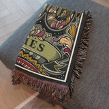 Decorative blanket with colorful patterns and 'Aries' text draped over a gray surface.